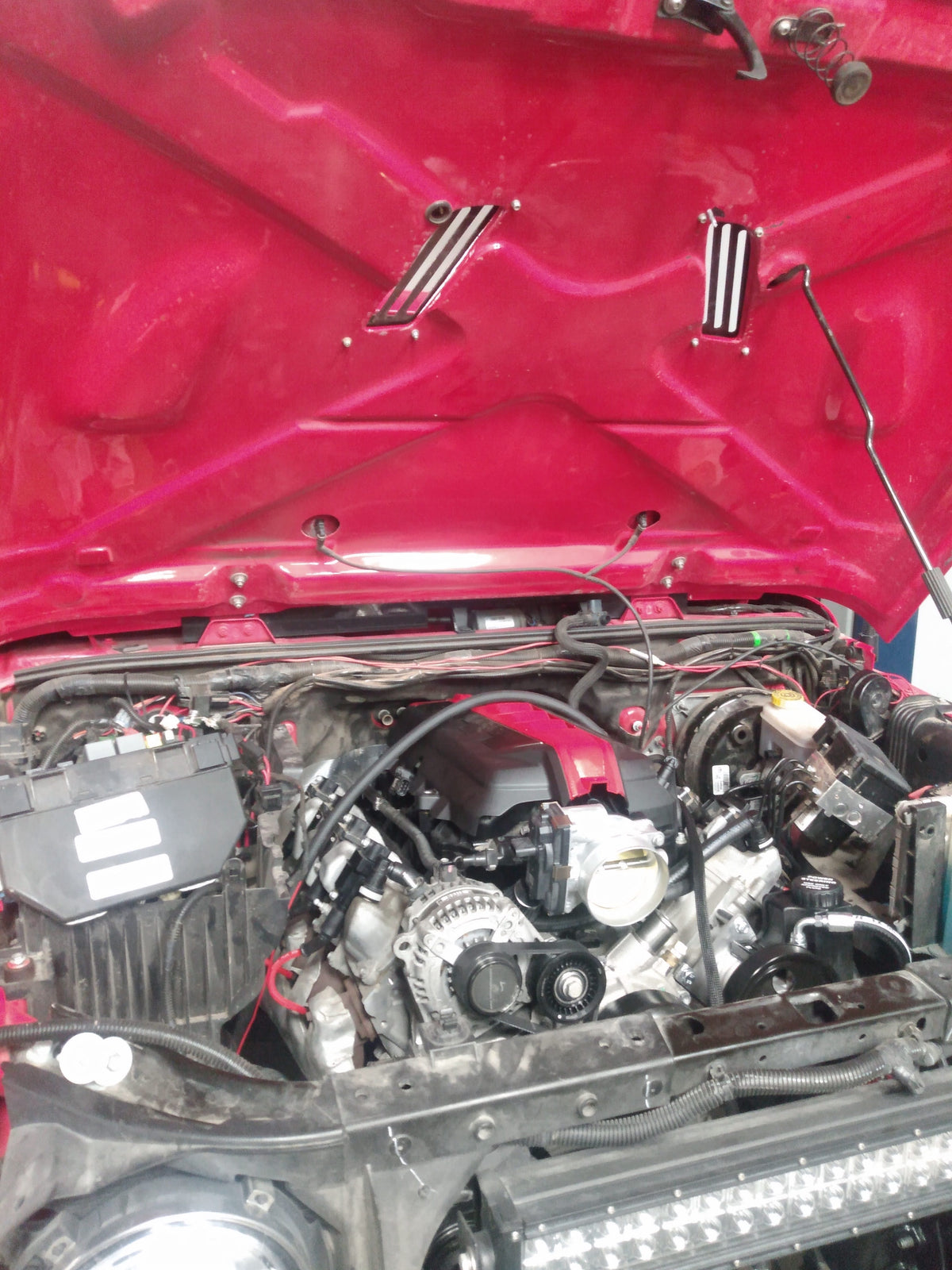 Wide view of completed Gen V LT V8 engine swap in red Jeep Wrangler JK showing full engine bay integration with Wicked Wrench Pro-Series harness installed