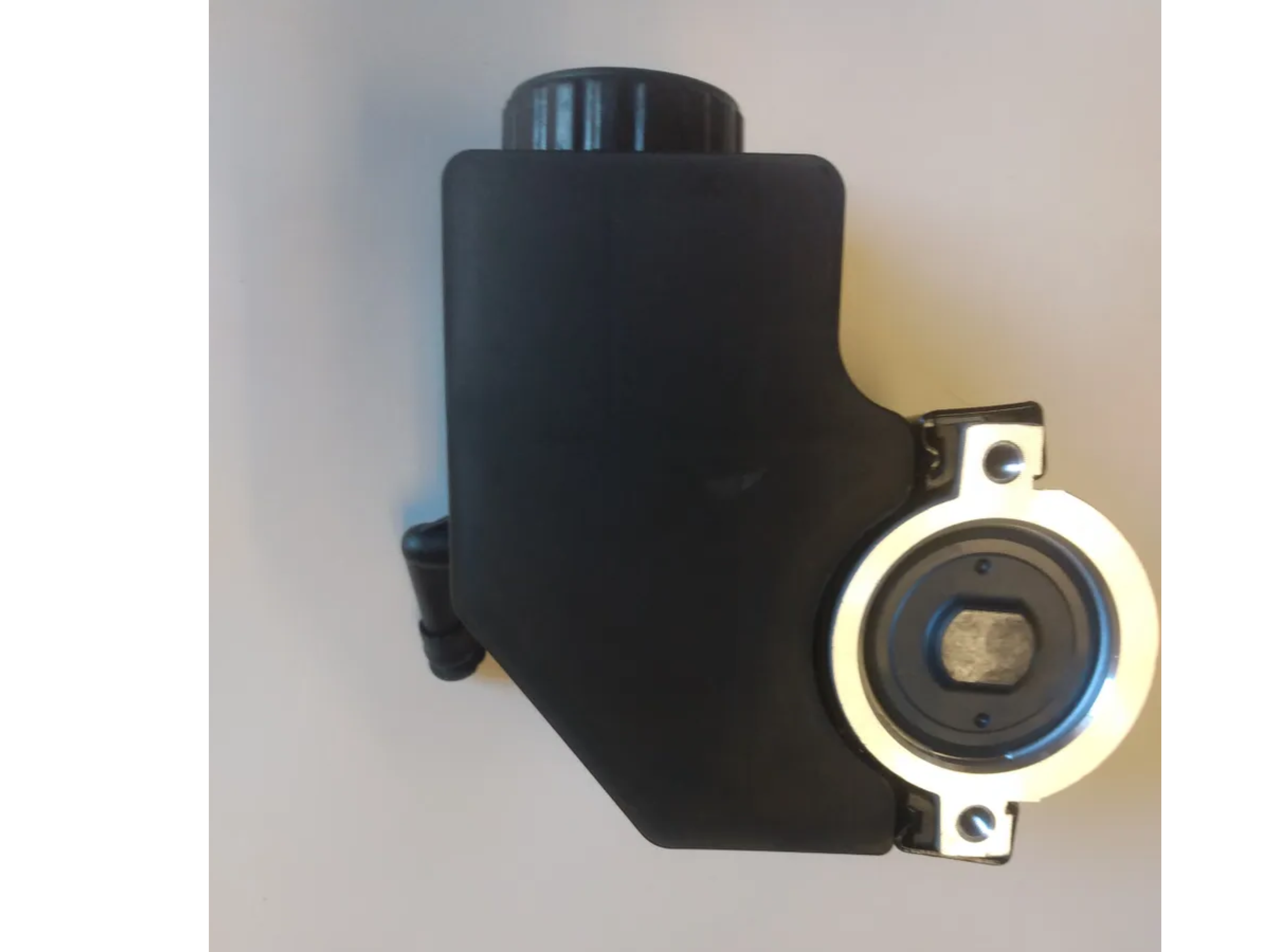 Eddie Motorsports Type II power steering pump back view layout on a shop bench detailing rear fluid port positions and mounting threads