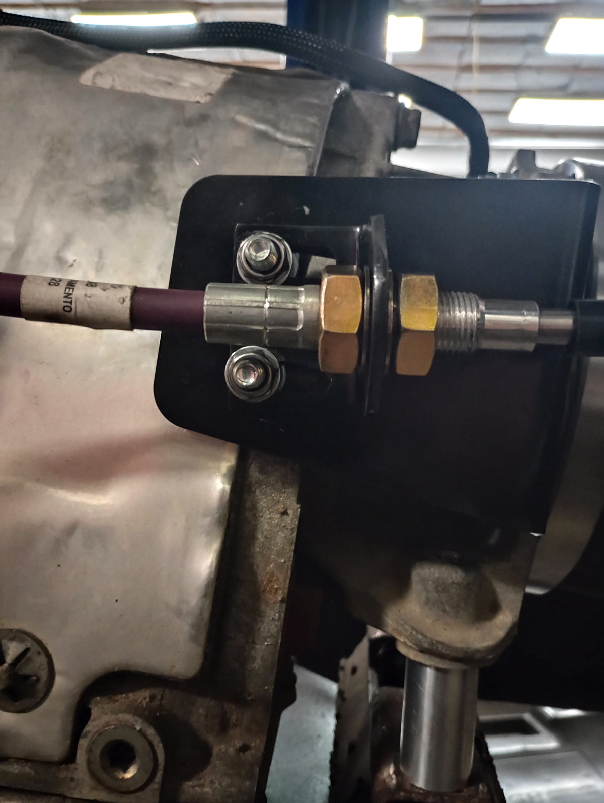 Close up side view of the Wicked Wrench Motorsports heavy duty transfer case beef up bracket bolted to a Jeep Wrangler drivetrain