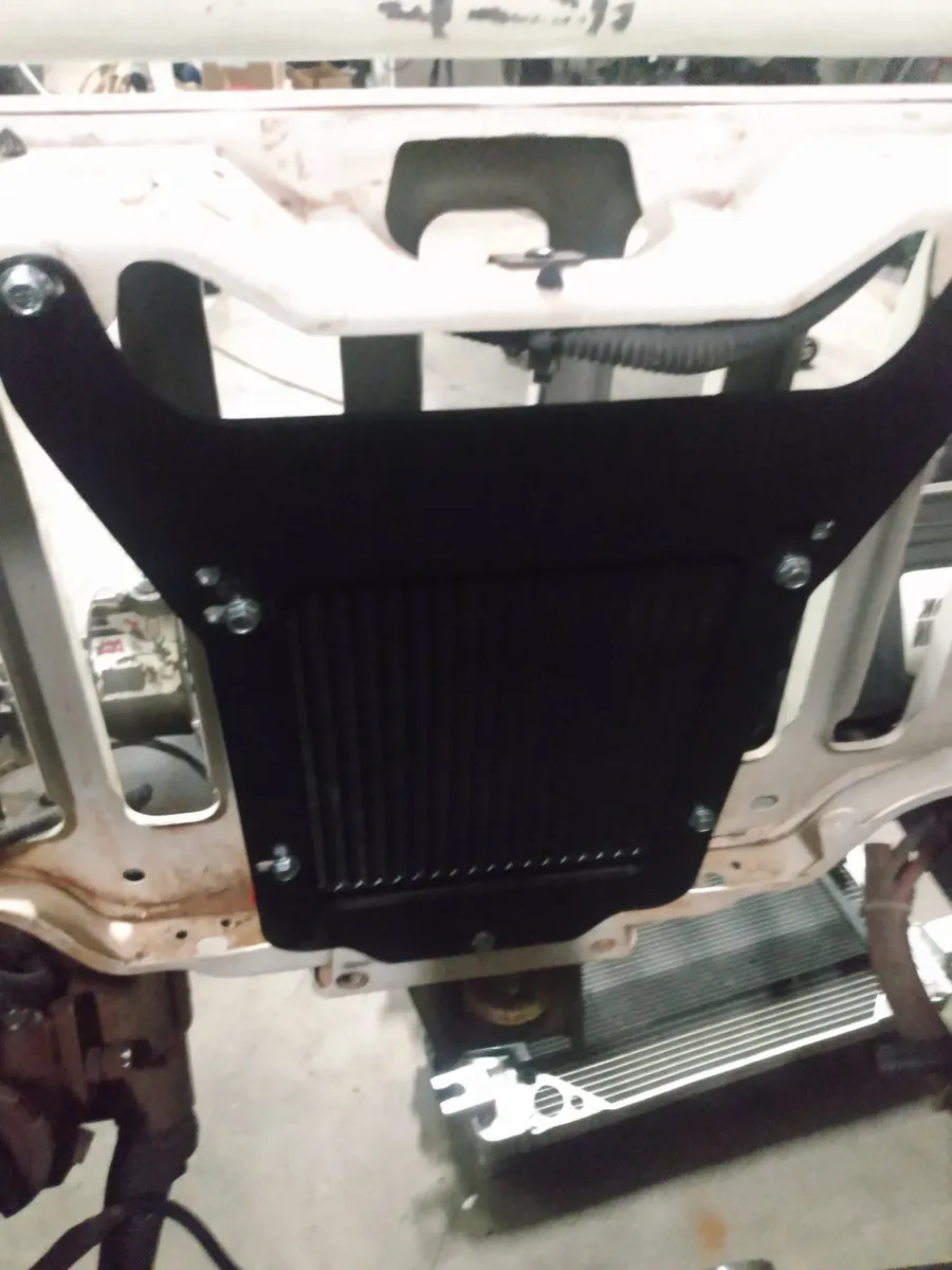 Wicked Wrench Motorsports heavy duty power steering cooler bracket back view mounted behind the grille of a Jeep Wrangler TJ or LJ chassis