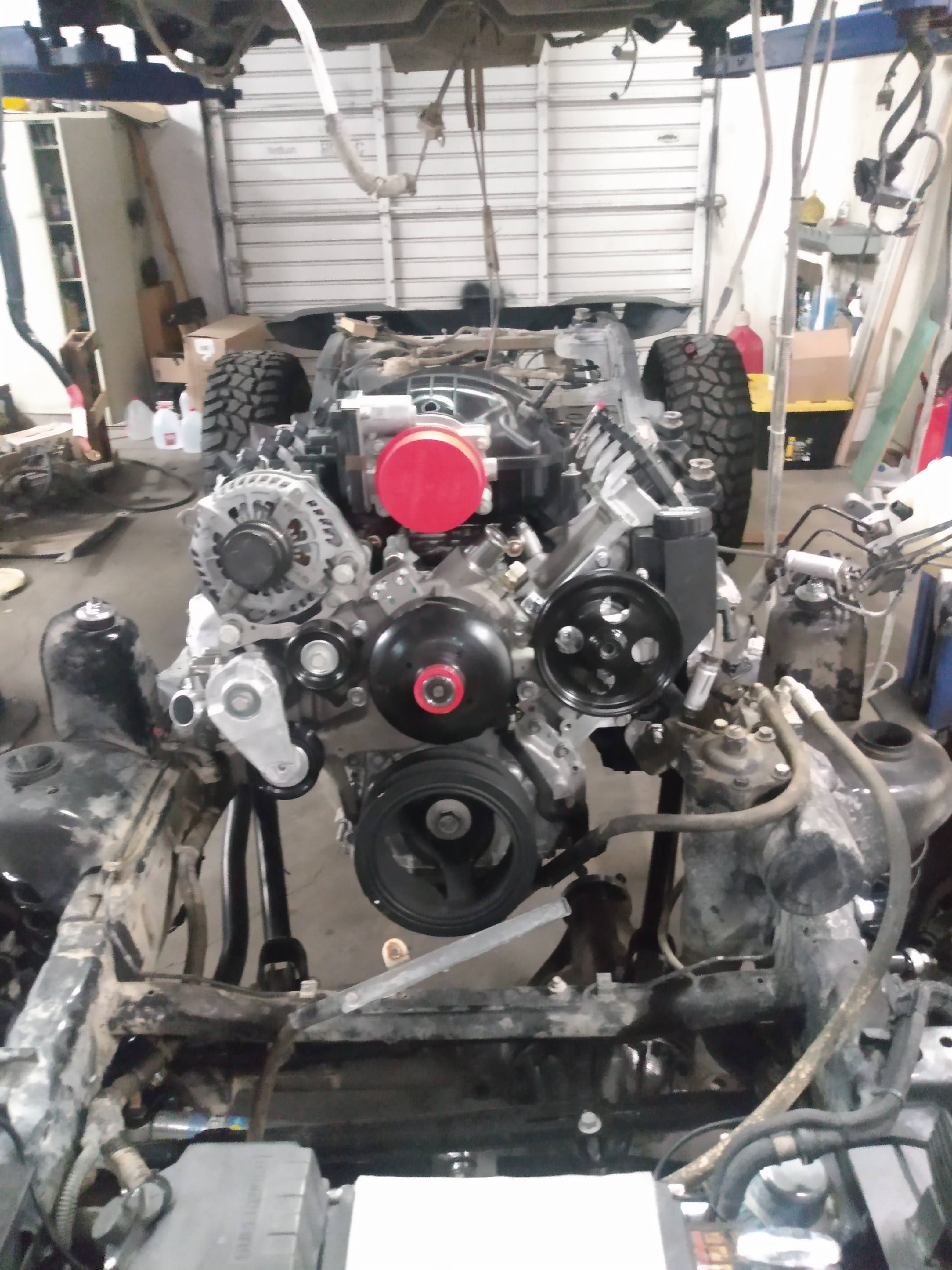 Gen V LT engine installed in Jeep JK/JKU bare frame on lift showing Wicked Wrench Pro-Series integration harness routing and engine placement